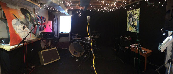 Microphone, drums, amplifiers and a stylized painting of Jimi Hendrix decorate the Jam Class rehearsal space